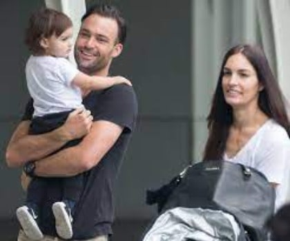 Matthew Le Nevez carrying his son, Levi by wearing black t-shirt.